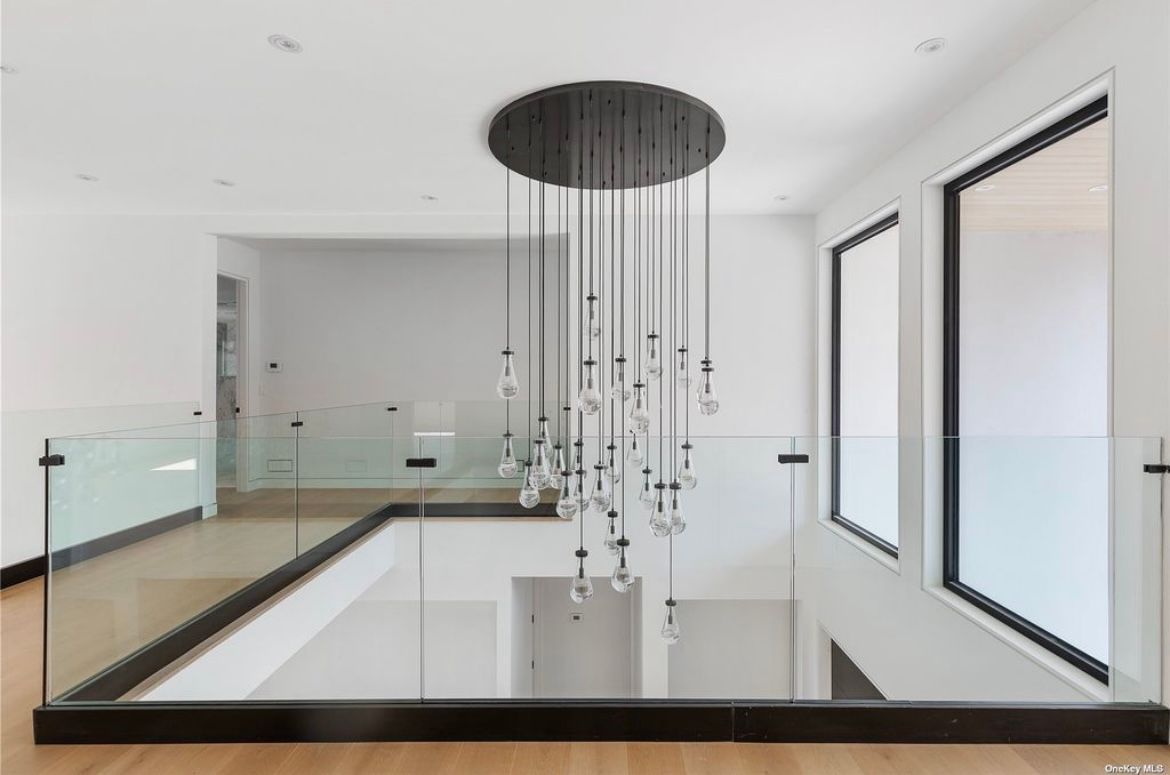 There is a chandelier hanging from the ceiling in the middle of the room