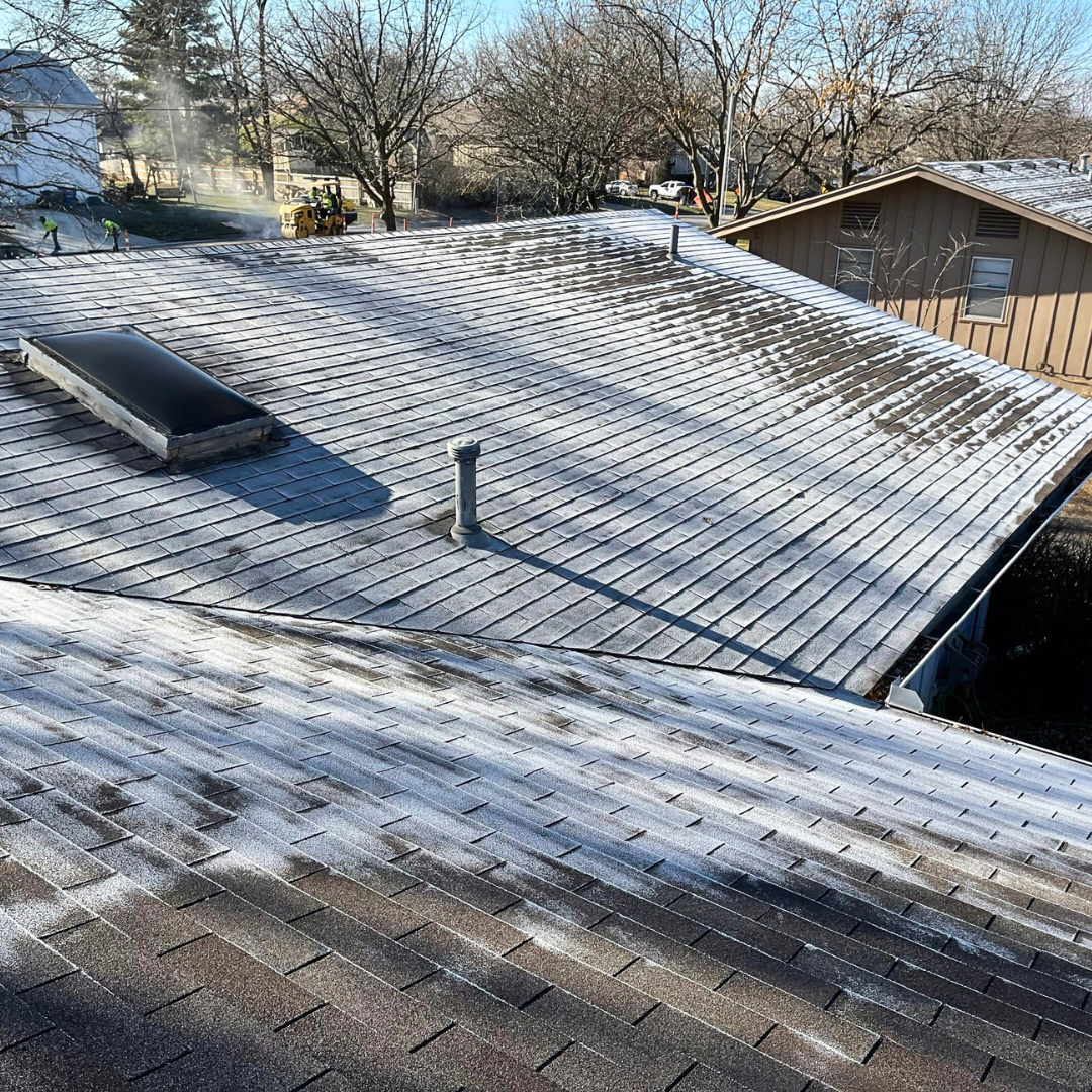 A close-up view of a residential roof covered in frost and snow, highlighting the formation of ice a