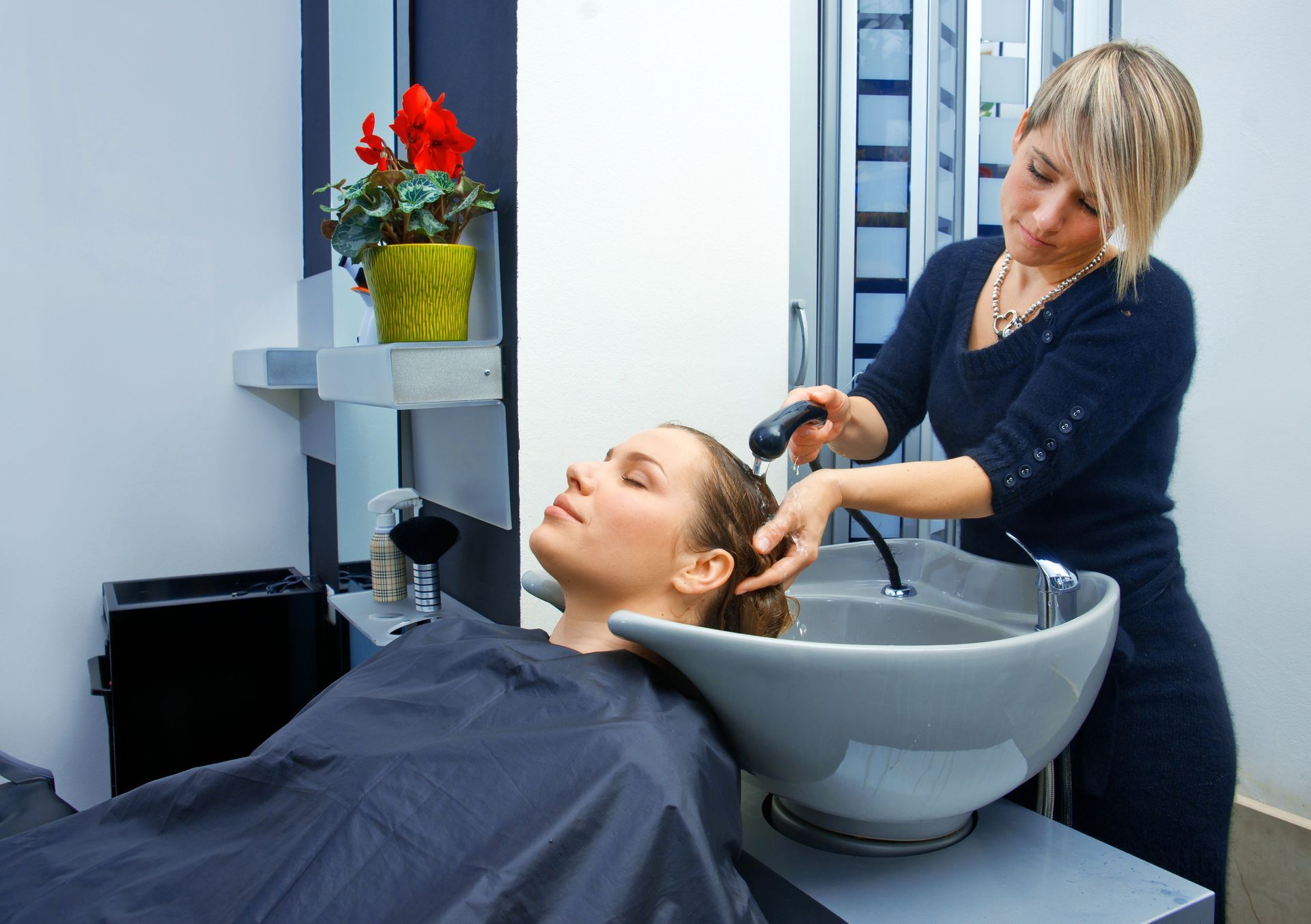 A woman is getting her hair washed at a salon.