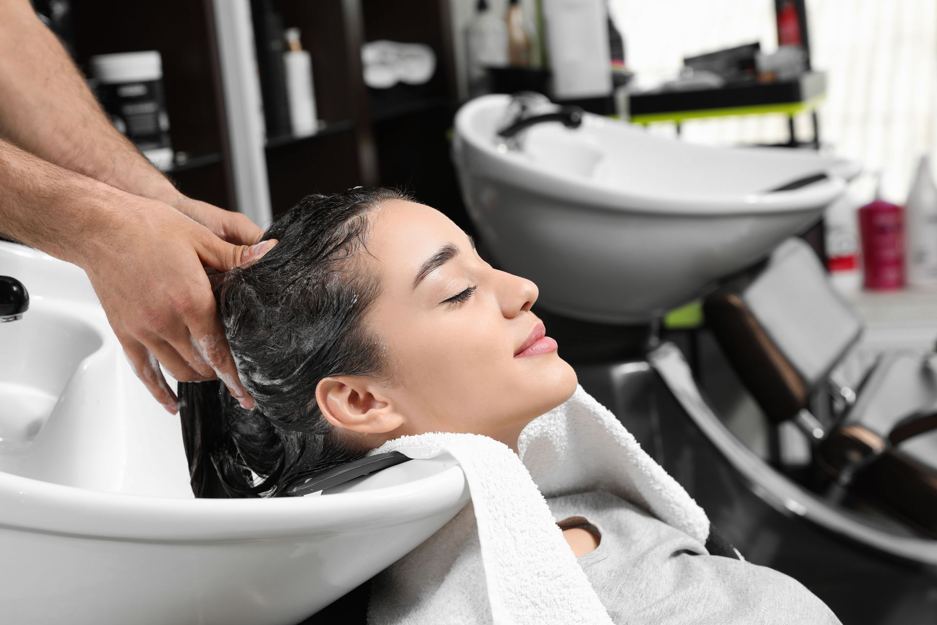 A woman is getting her hair washed in a salon.
