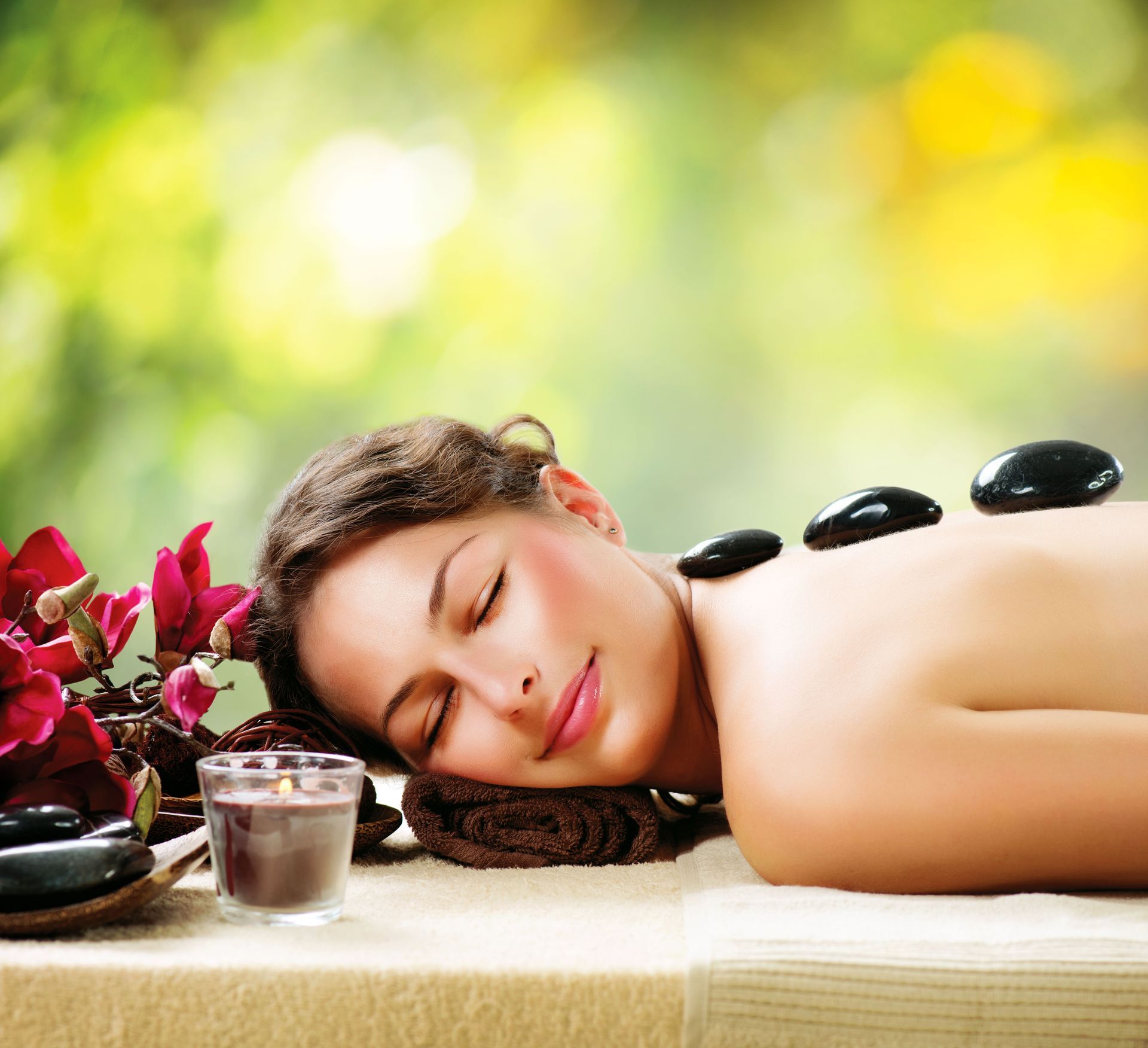 A woman is laying on a table with hot rocks on her back.