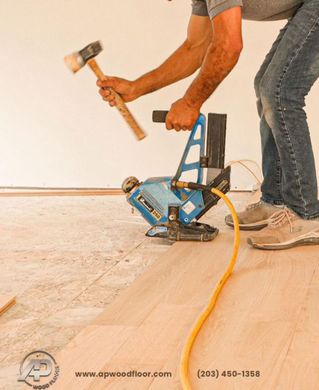 A man is holding a hammer while working on a machine