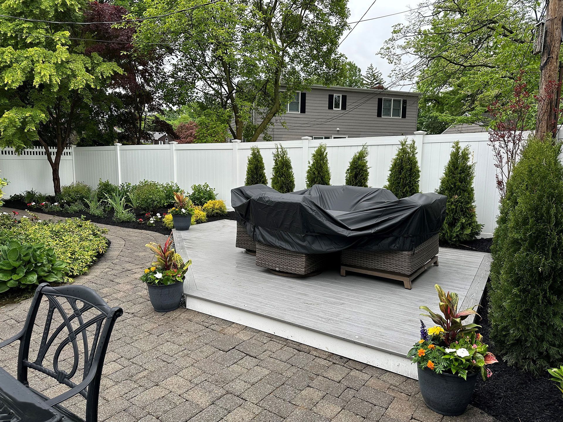 A patio with a table and chairs under a black cover