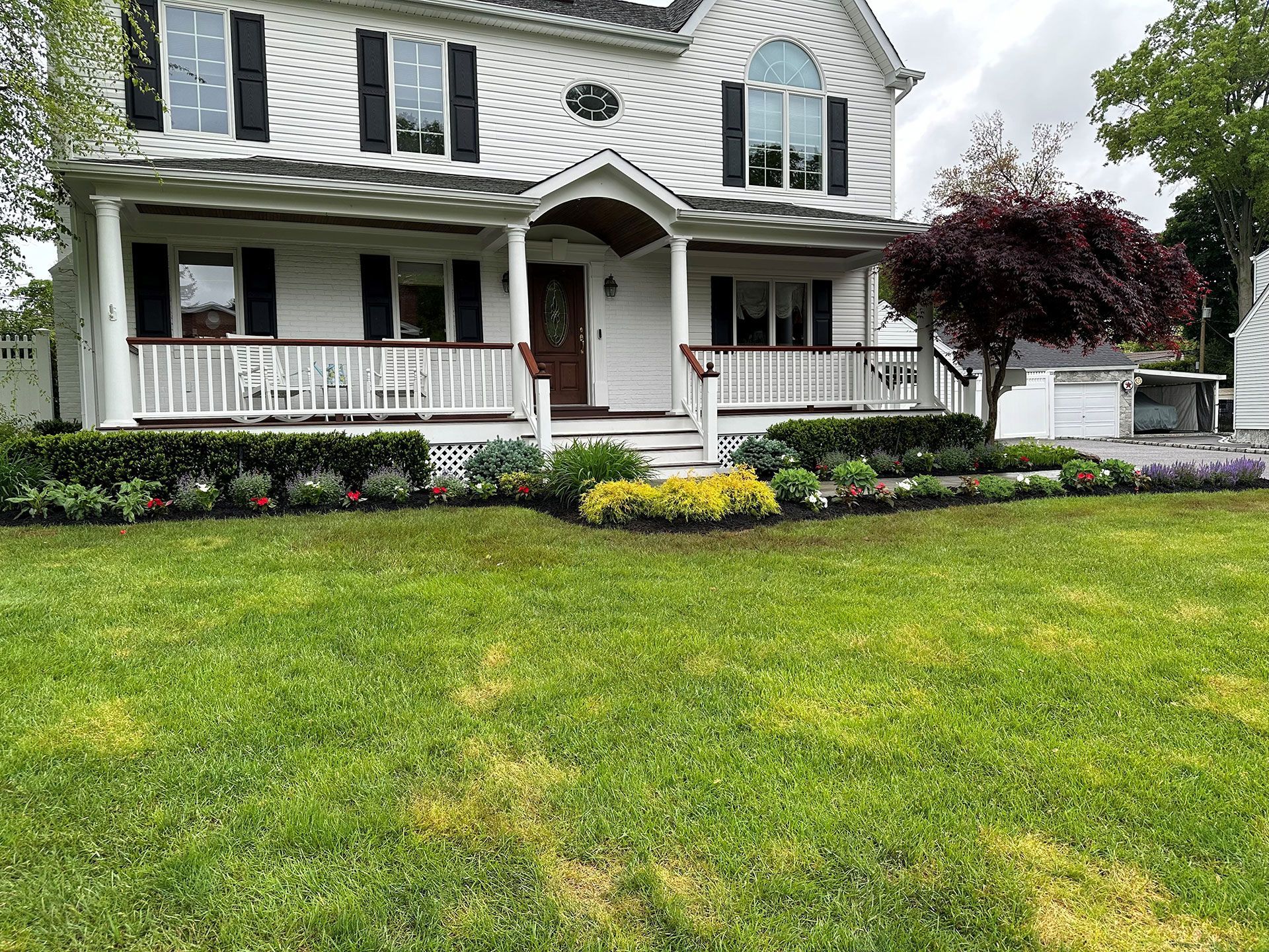 A large white house with a spacious lawn in front of it