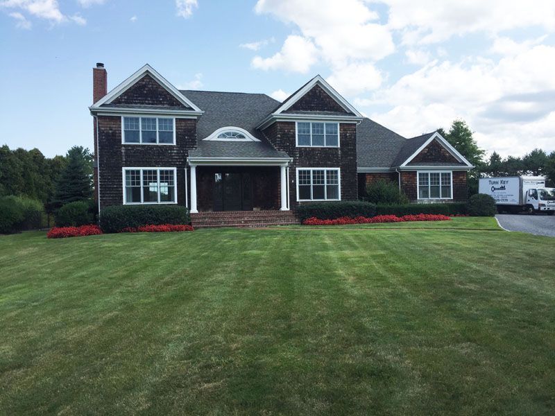 Before photo of a large house with a lush green lawn in front of it