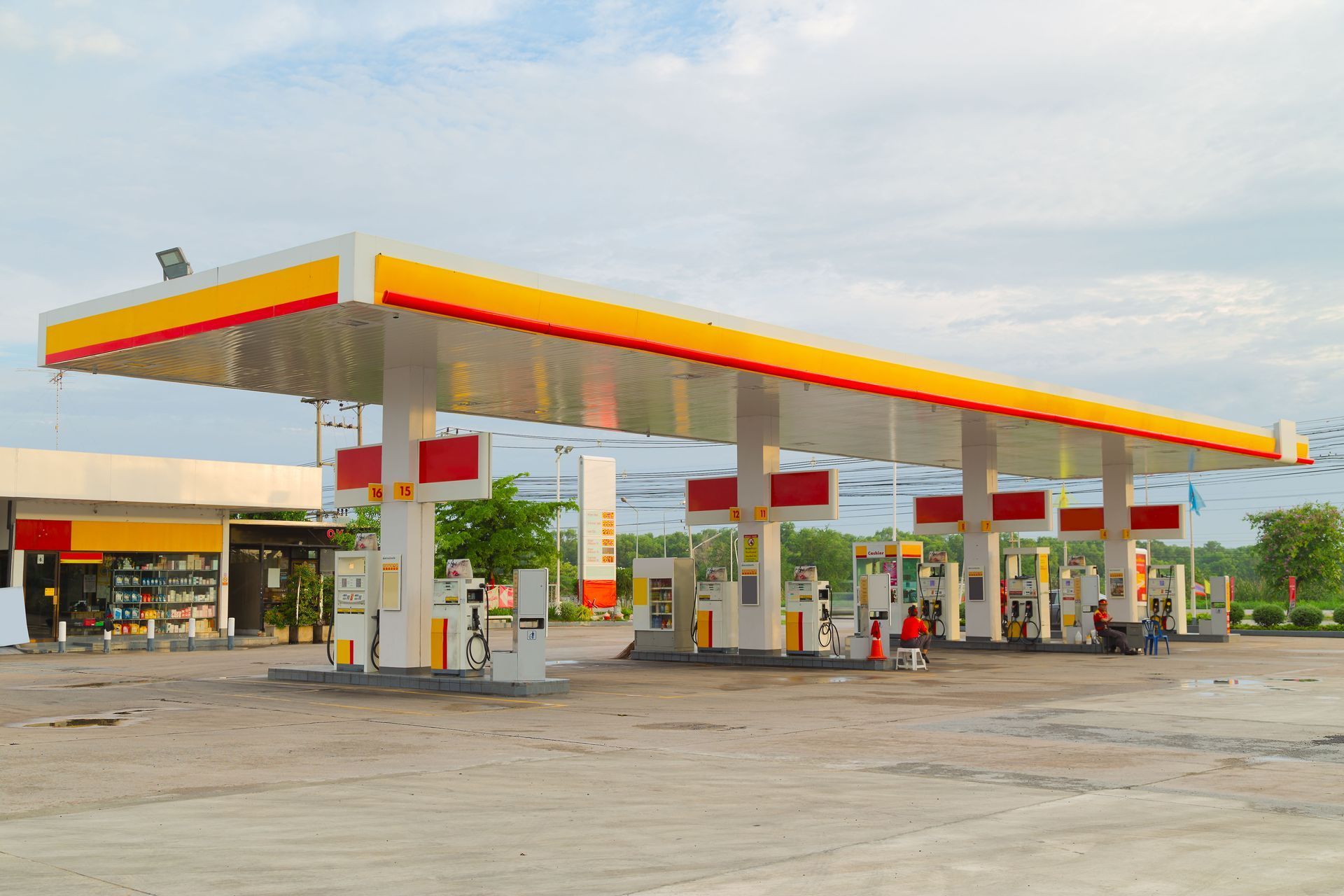 Shell gas station with a yellow and red canopy and fuel pumps on a paved lot