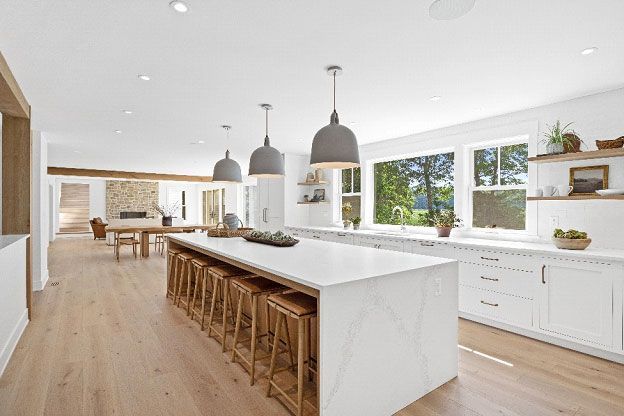 There is a wooden table in the middle of the kitchen.