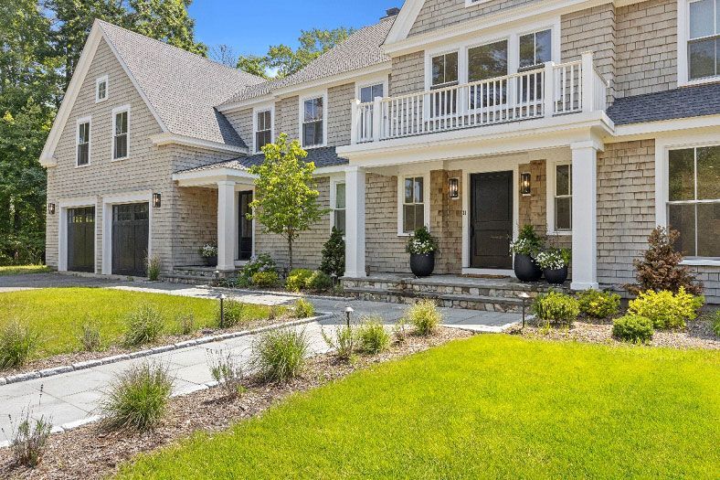 A large brick house with a large lawn in front of it