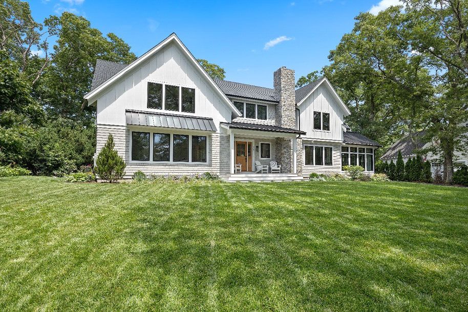 A large white house with a large lush green lawn