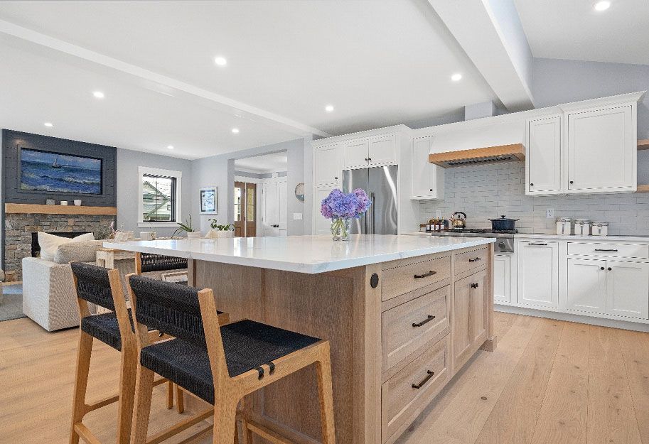 A kitchen with white cabinets and chairs
