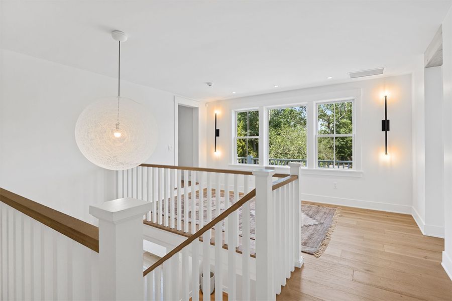 Staircase with a wooden railing in the middle of the room.