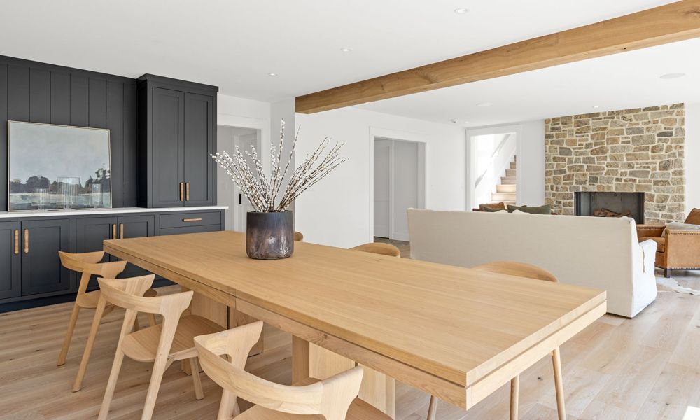 A dining room with a long wooden table and chairs.
