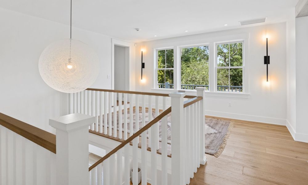 There is a staircase with a wooden railing and a wooden floor.