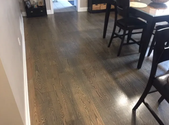 Hardwood floors in a room with a table and chairs, near a doorway.