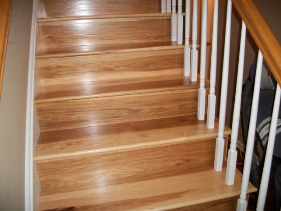 Wooden staircase with white banister and handrail.