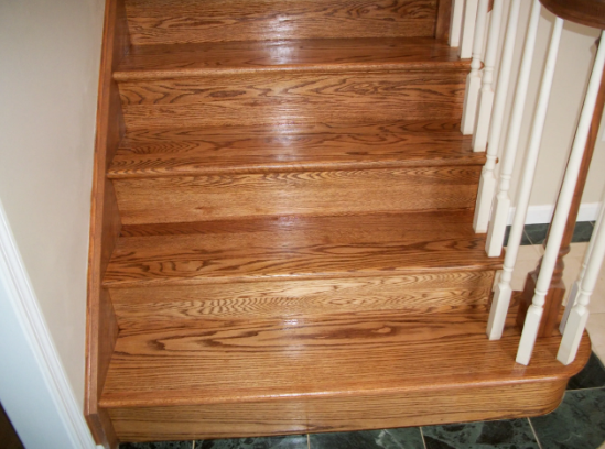 Wooden staircase with handrail. Steps are varnished oak.