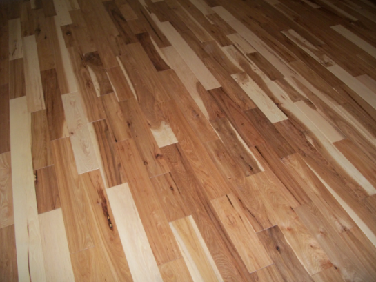 Wooden plank flooring, varying shades of light and dark brown.