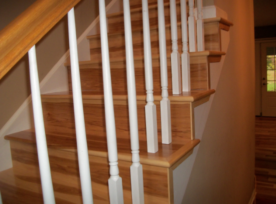 Wooden staircase with white balusters, leading up, corner view.