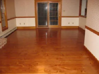 Empty room with polished hardwood floors and white-paneled walls.