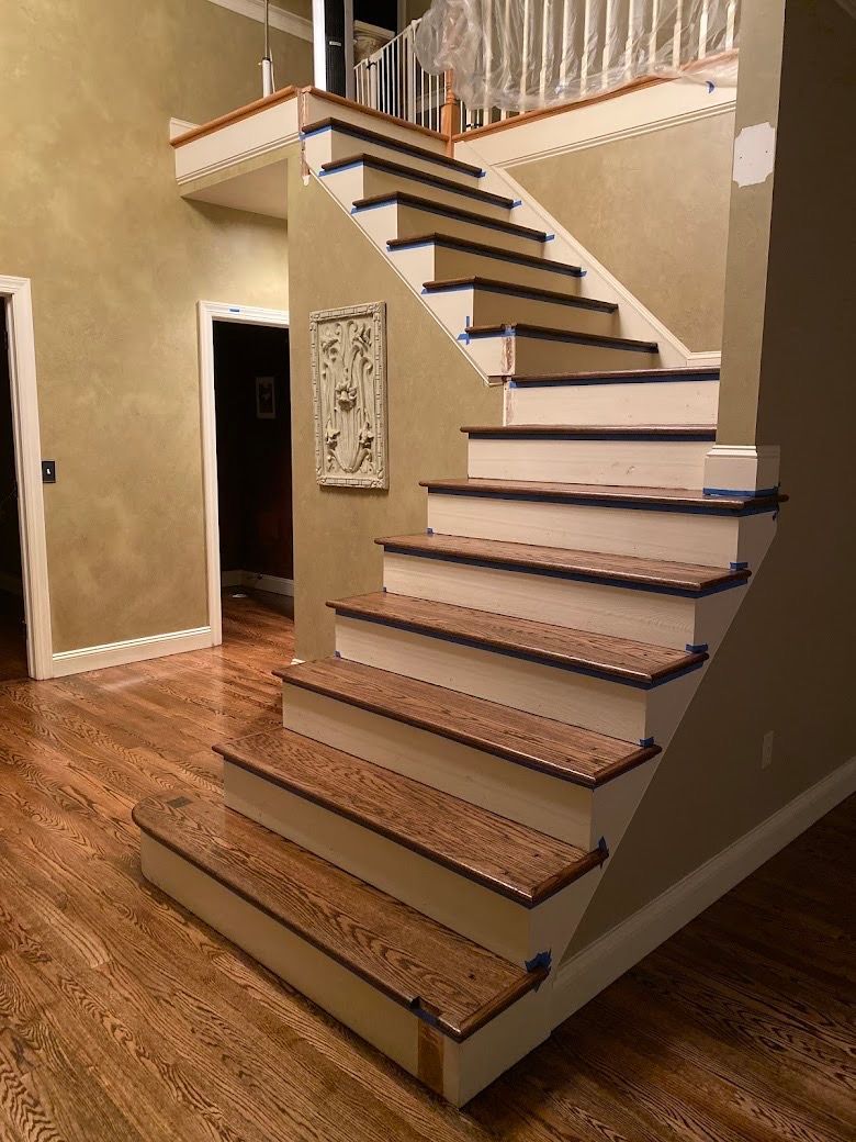 Wooden staircase with painted white risers and dark brown treads.