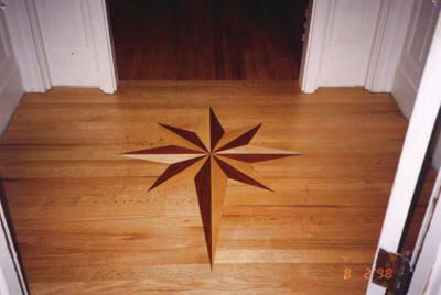 Wooden floor with inlaid starburst pattern, framed by doorways.