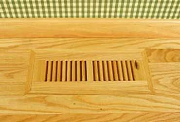 Wooden floor vent with rectangular cut and angled slats.