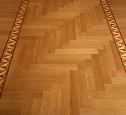 Wooden parquet flooring with a zig-zag pattern and decorative border.