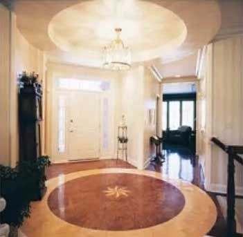 Elegant entryway with a circular patterned floor and chandelier.