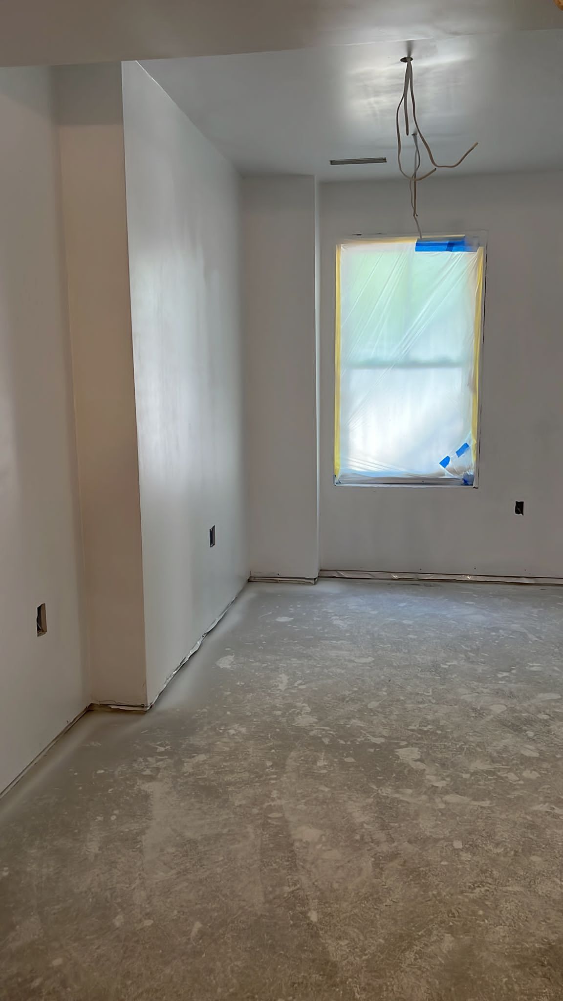 An empty room with white walls and a window.