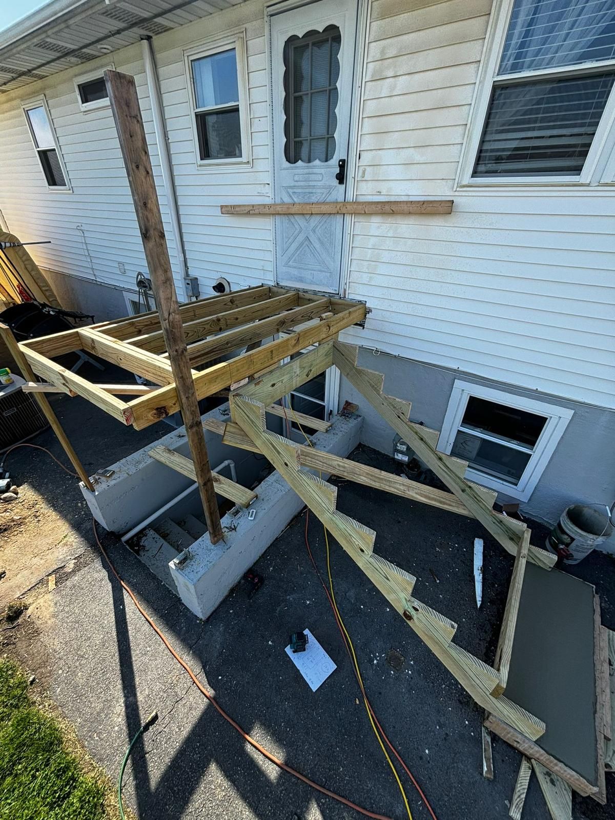A wooden deck is being built on the side of the house.