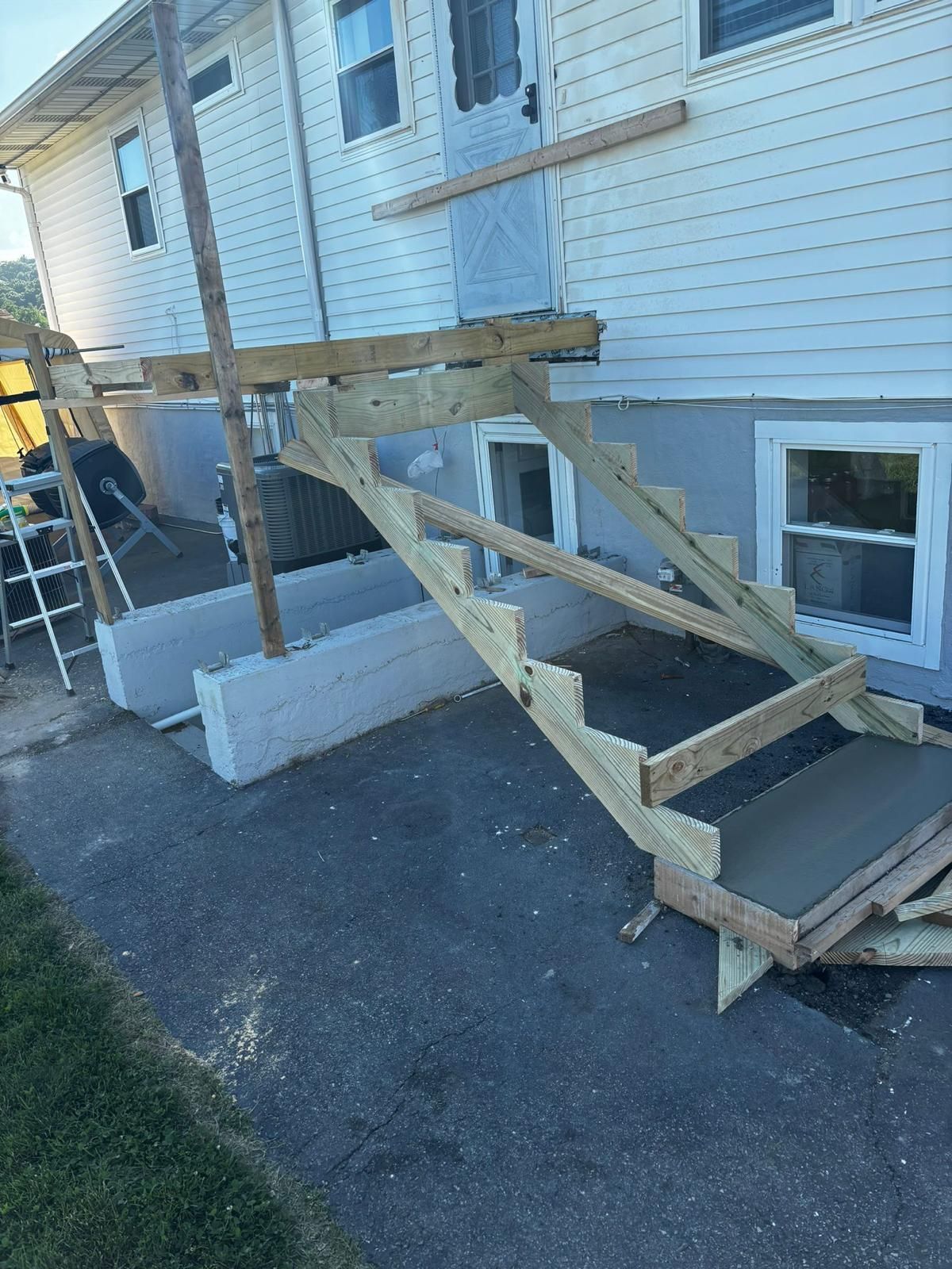 A wooden deck is being built on the side of the house.
