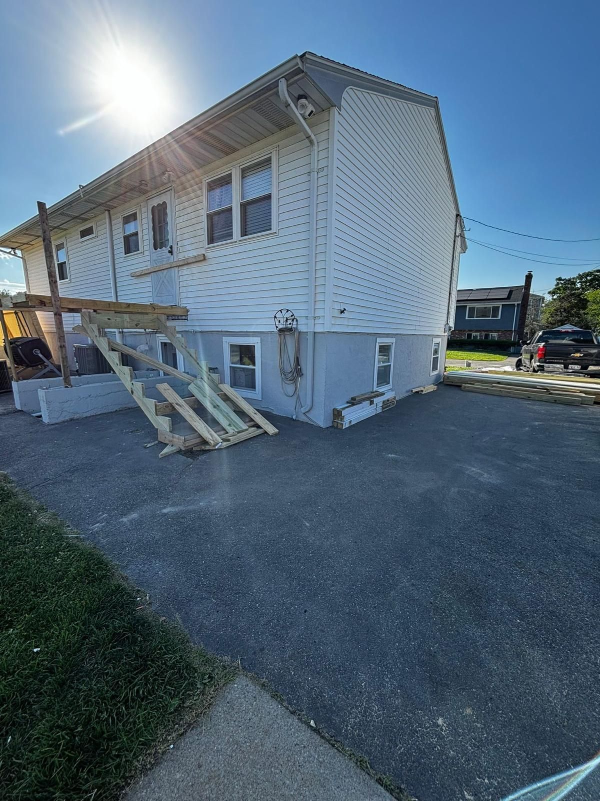 A white house with a wooden deck on the side of it.