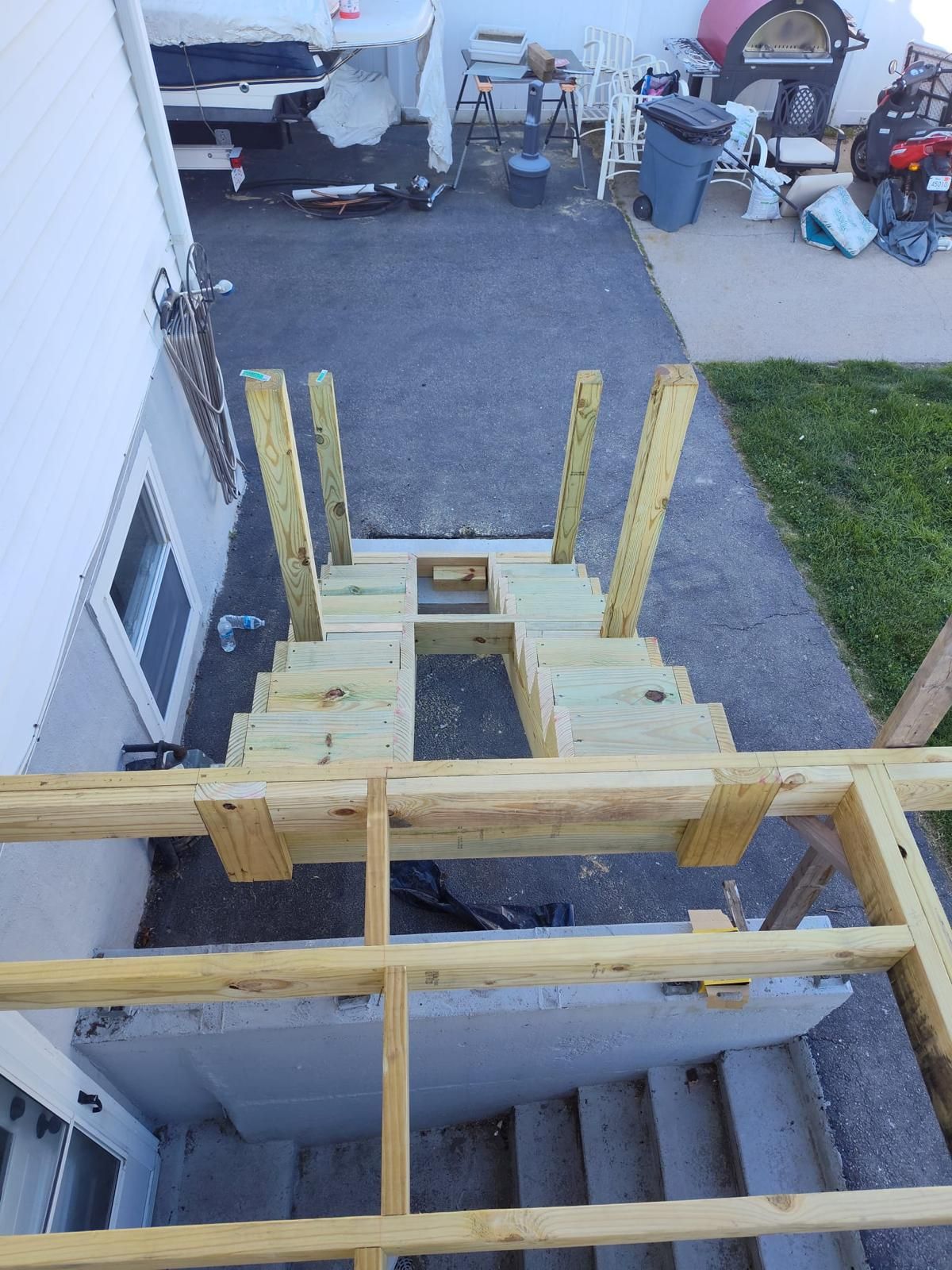 A wooden deck is being built in the backyard of a house.