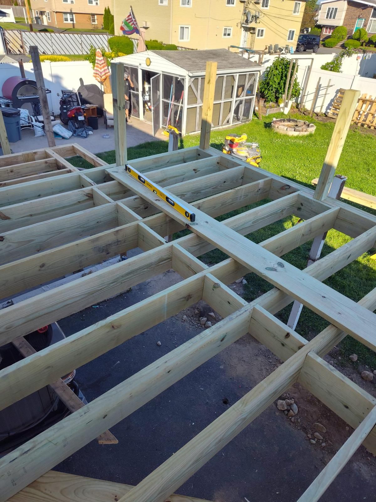 A wooden deck is being built in the backyard.