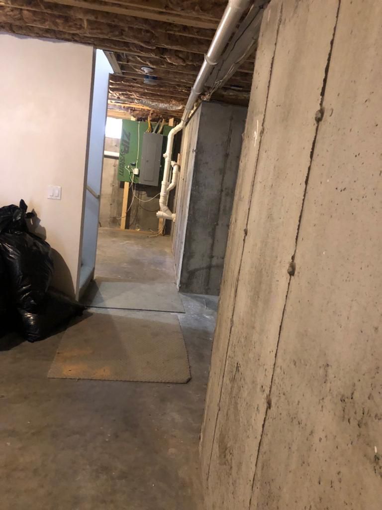 A basement with a lot of concrete walls and pipes.