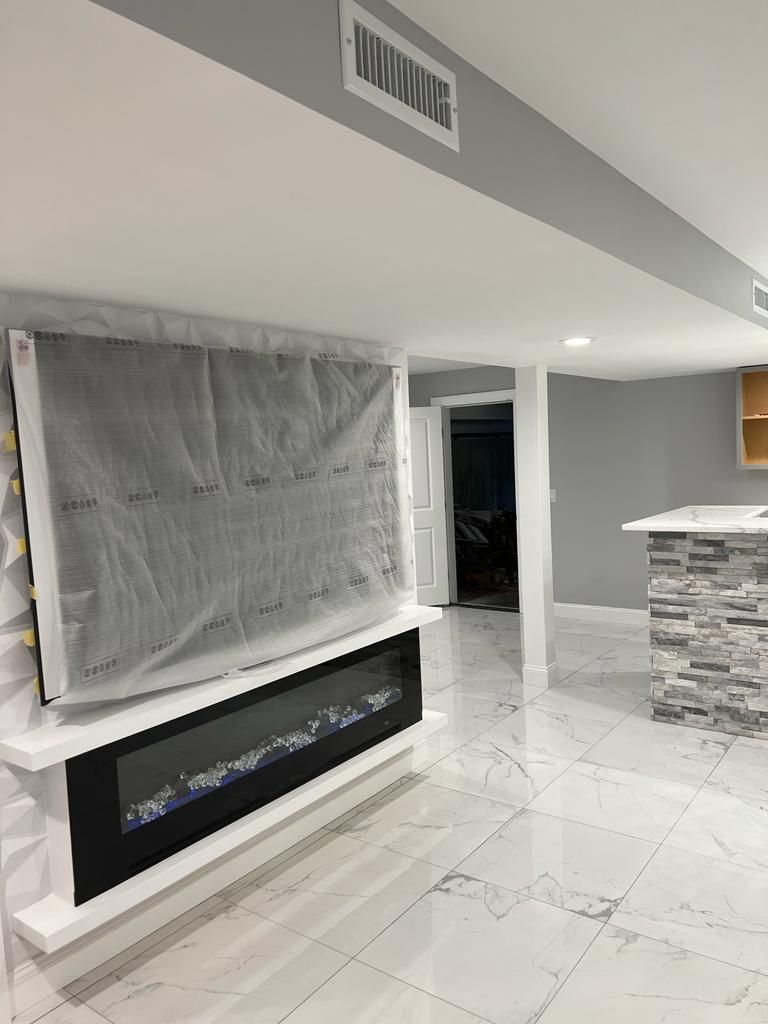A living room with a fireplace and a flat-screen TV.