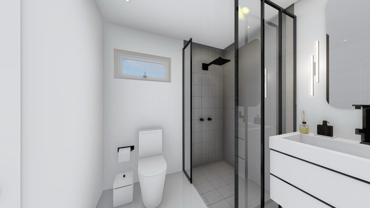 A bathroom with a toilet , sink and shower.