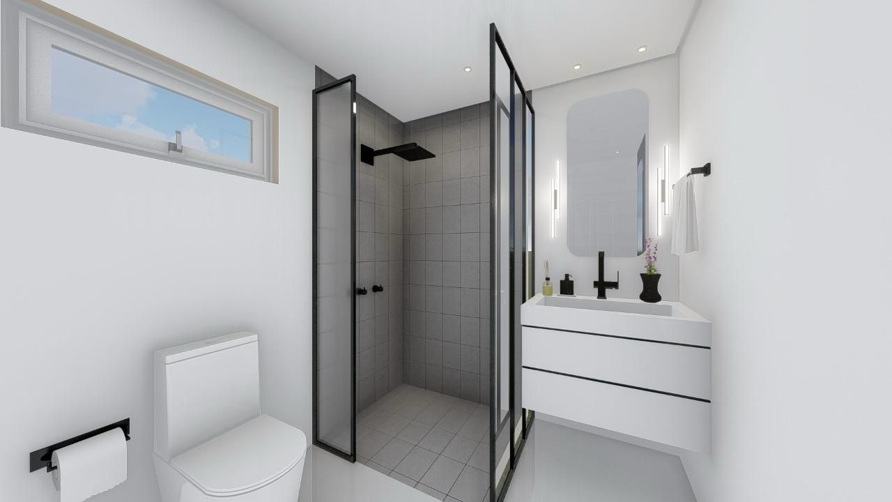 A bathroom with a toilet , sink , shower and window.