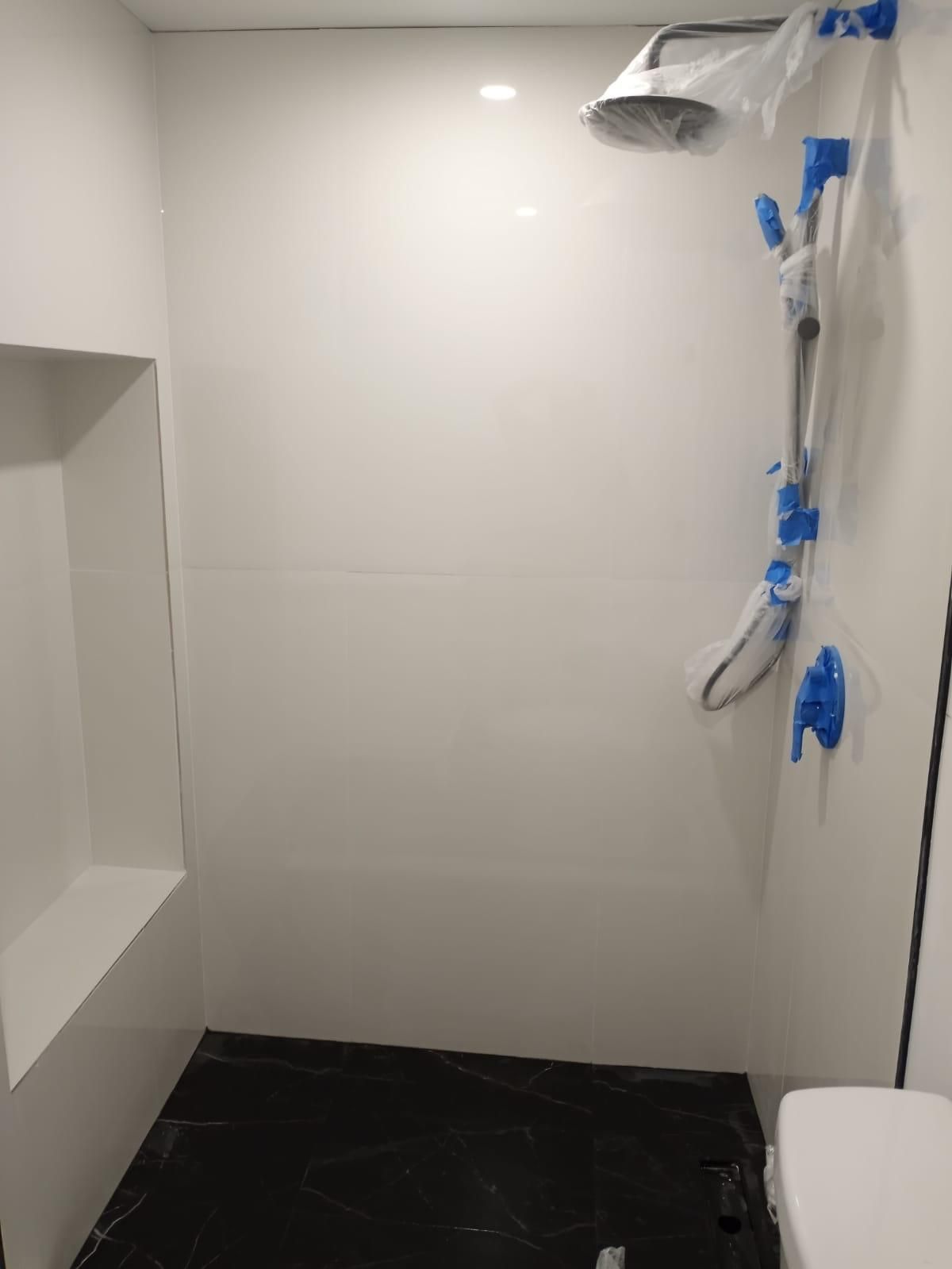 A bathroom with a shower and a toilet.