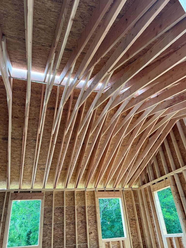 The ceiling of a building under construction with a lot of wooden beams.