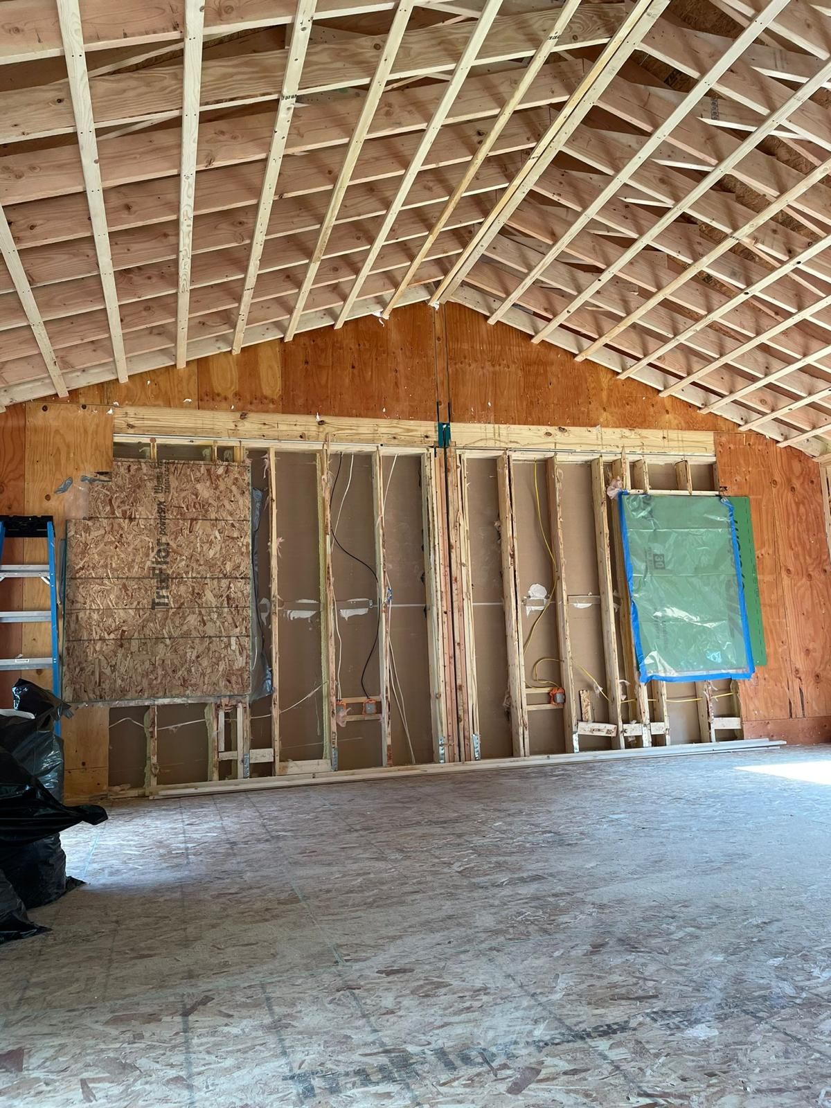 The inside of a building under construction with a ladder in the background.