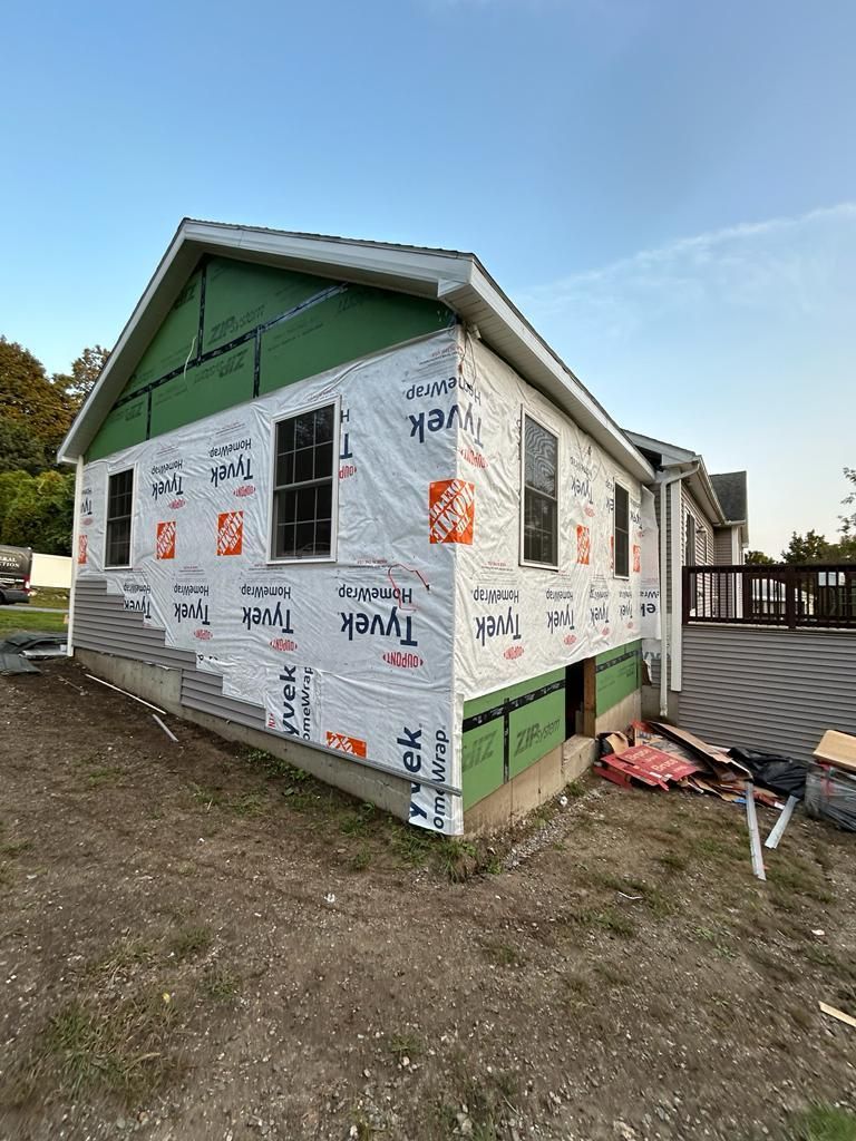 A house is being built with a lot of siding on it.