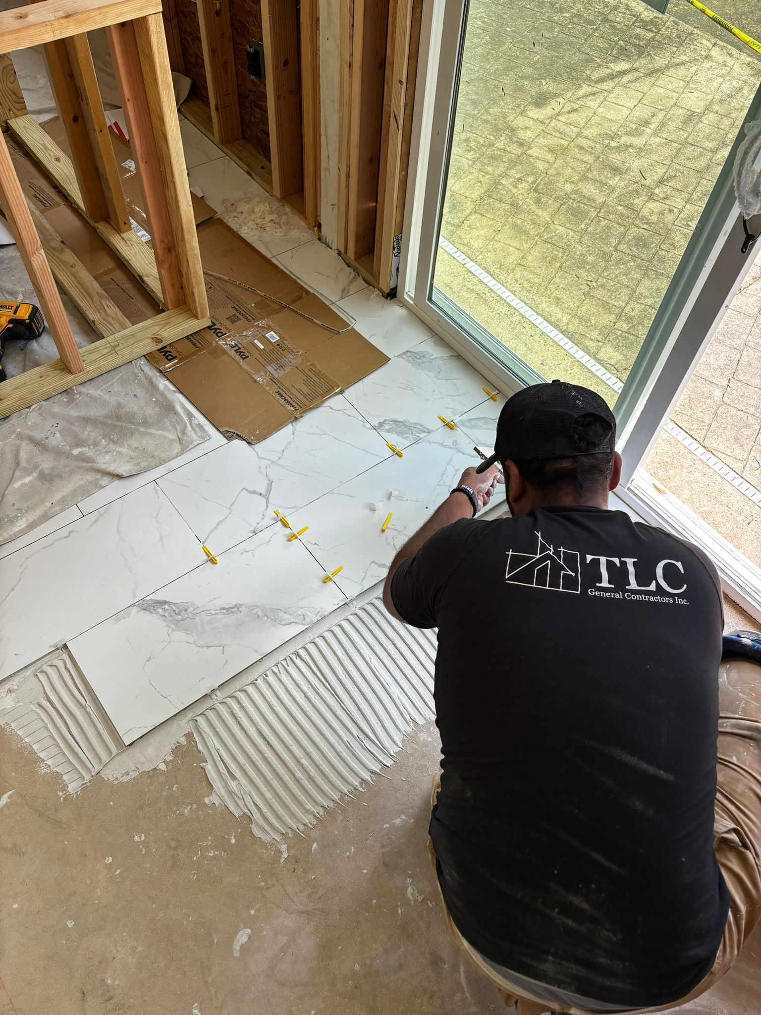 A man in a black shirt is sitting on the floor in a room.