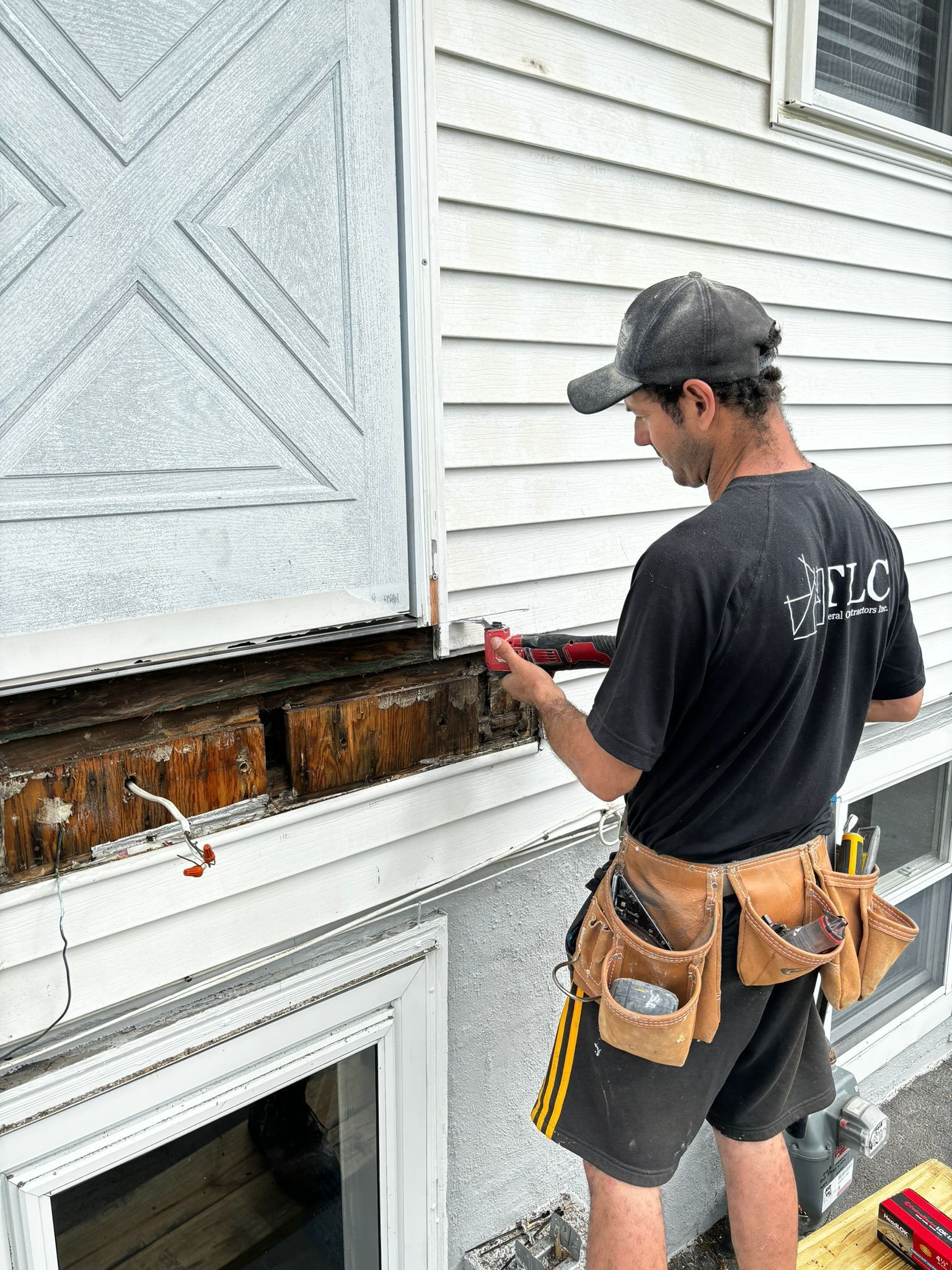 A man is working on the side of a house.