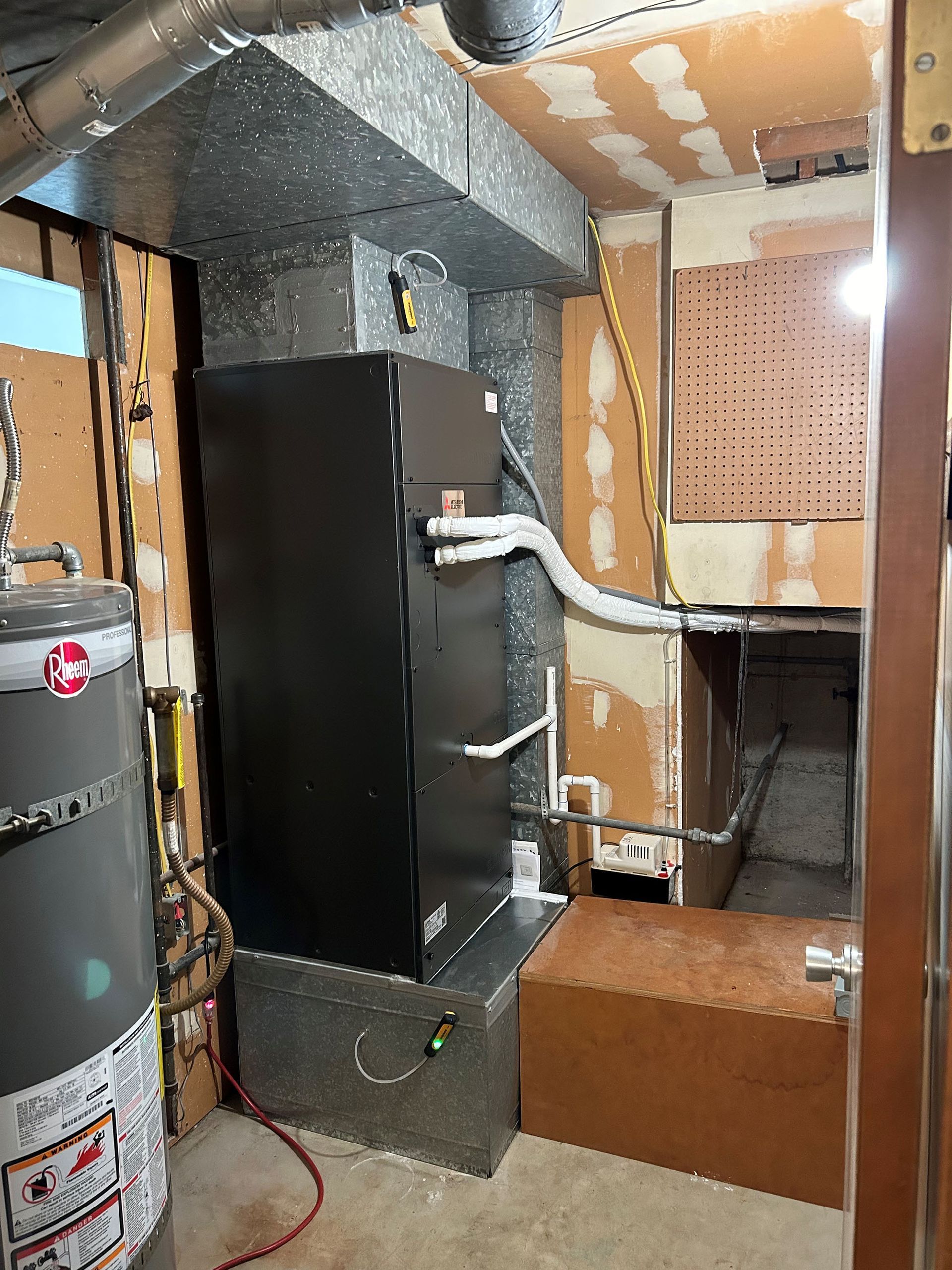 A room with a heater and a water heater in it.