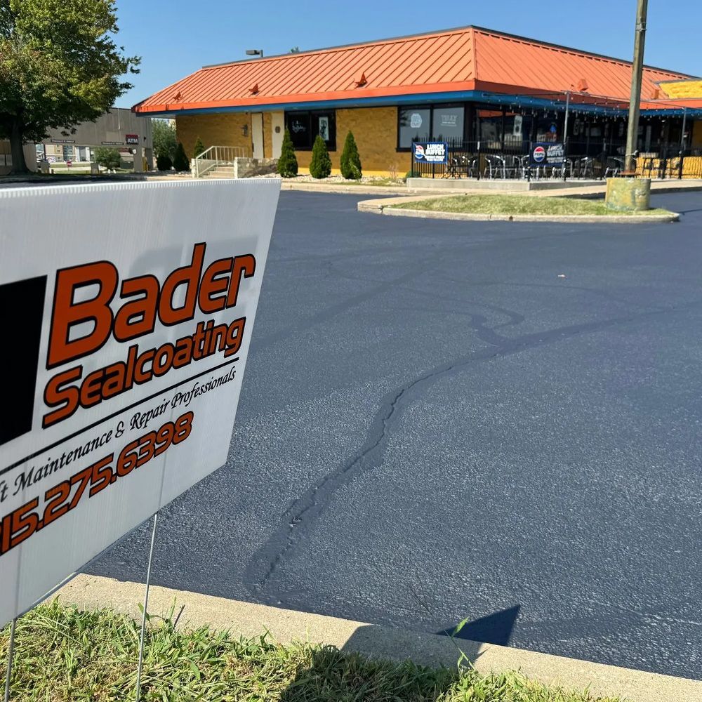 A sign in front of a building that says bader sealcoating