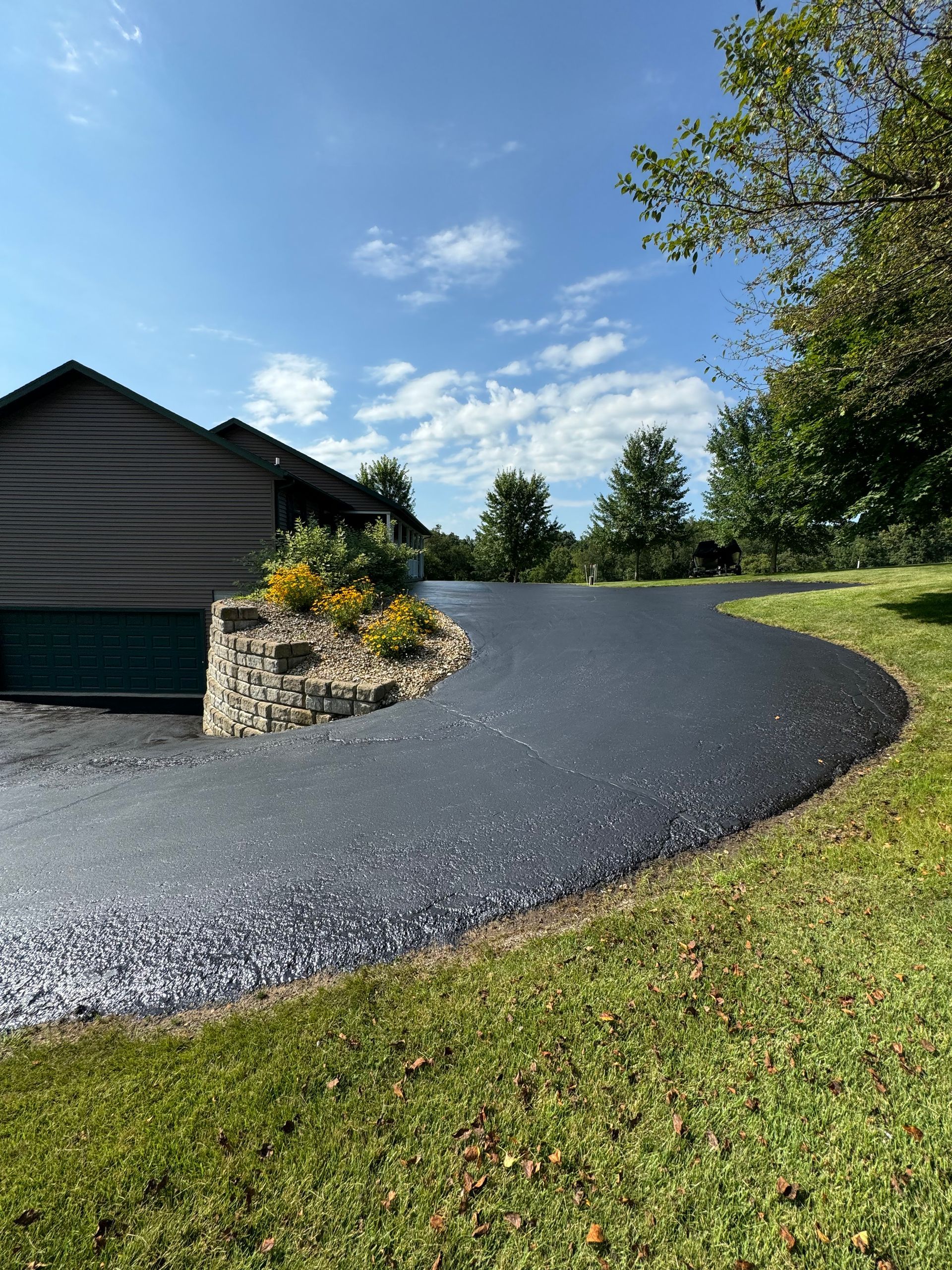 A curved driveway leading to a house with a garage.