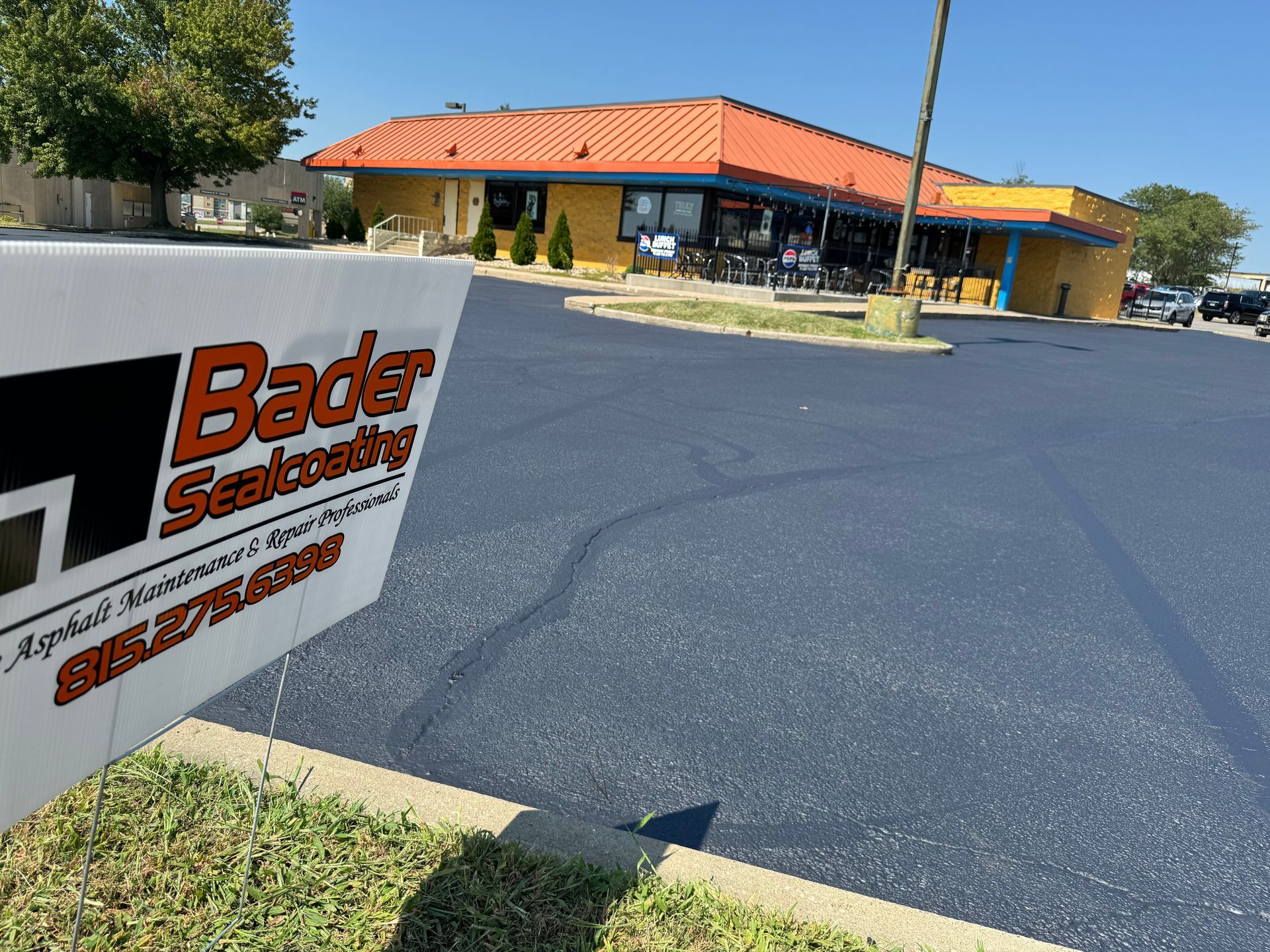 A sign in front of a building that says bader sealcoating