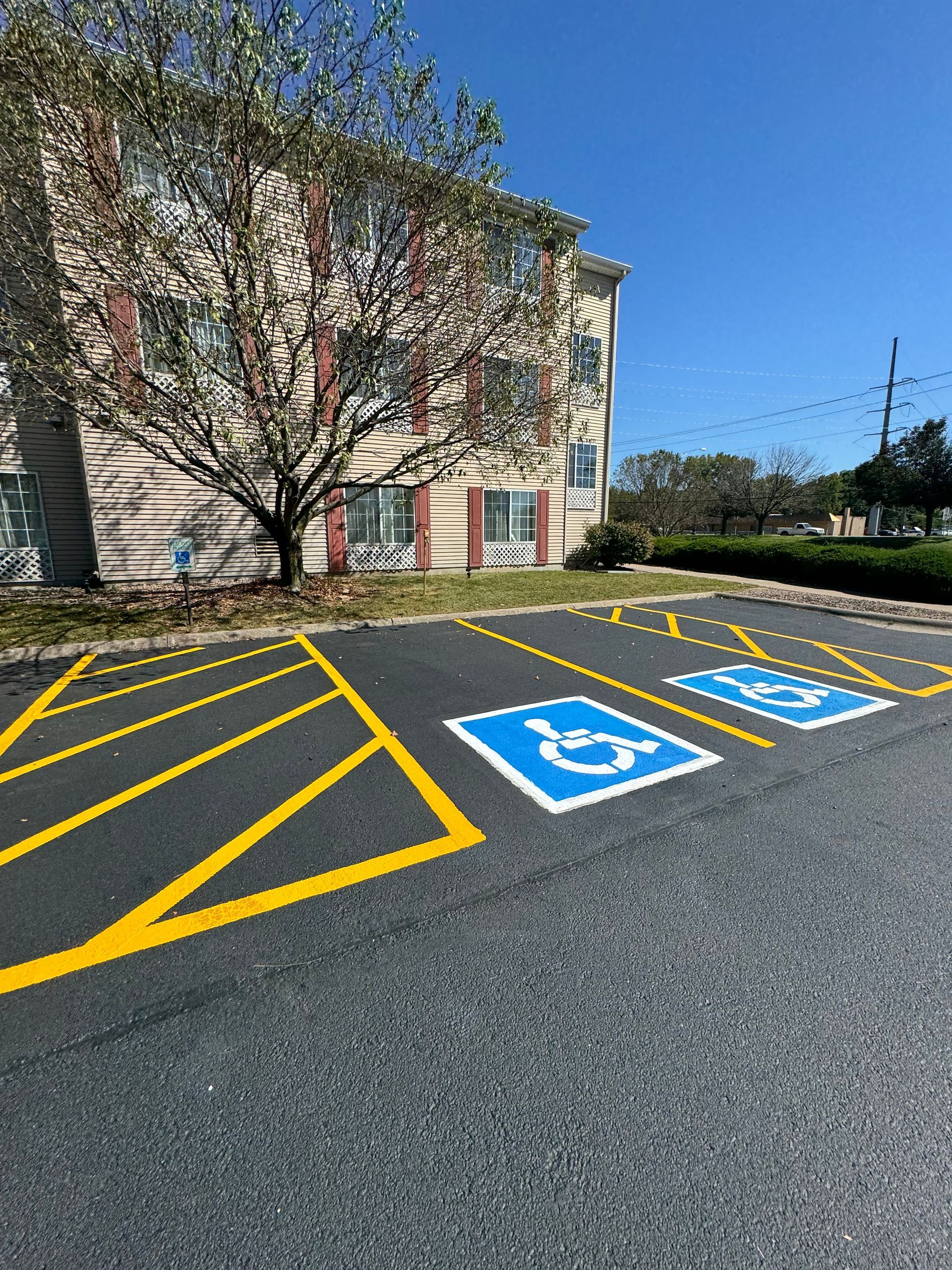 A handicapped parking lot with a building in the background
