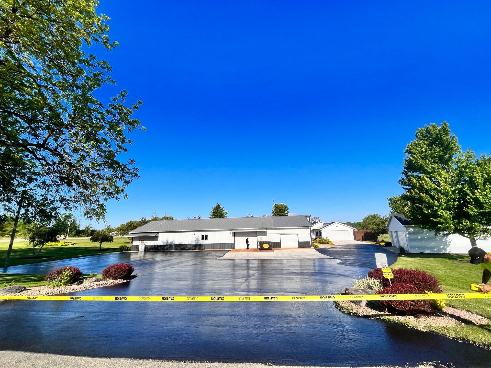A house with a large driveway and a yellow tape around it